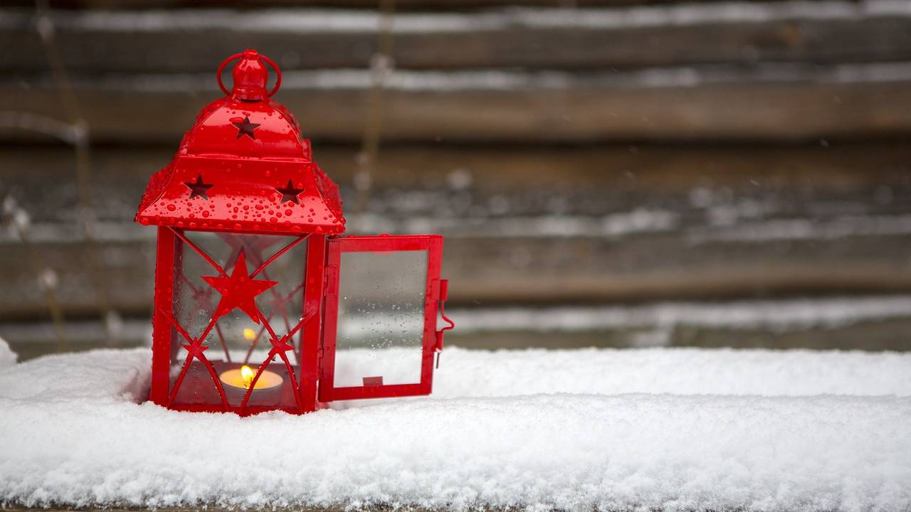 Punainen lyhty lumen peittämällä penkillä.